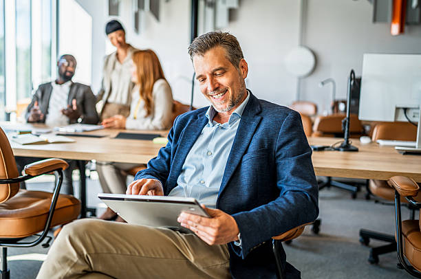 istock Happy businessman working on digital tablet in office 2241652352