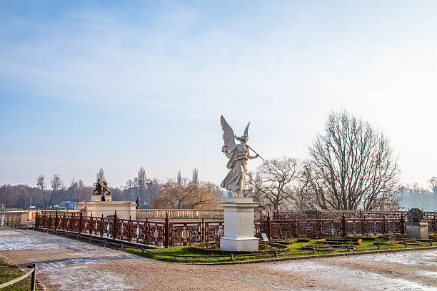 Shwerin, Germany February 04, 2025: Angel statue stands in park surrounded by winter landscape and trees in the background.