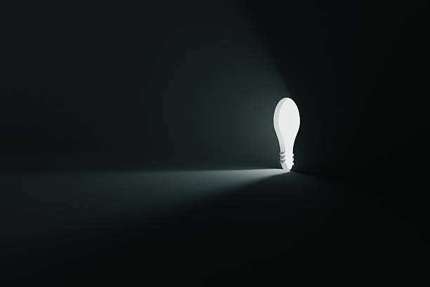 Creativity light bulb in a hole in the wall shines on a black background, a creative idea. Think different, concept. Light in the dark. New idea and start-up