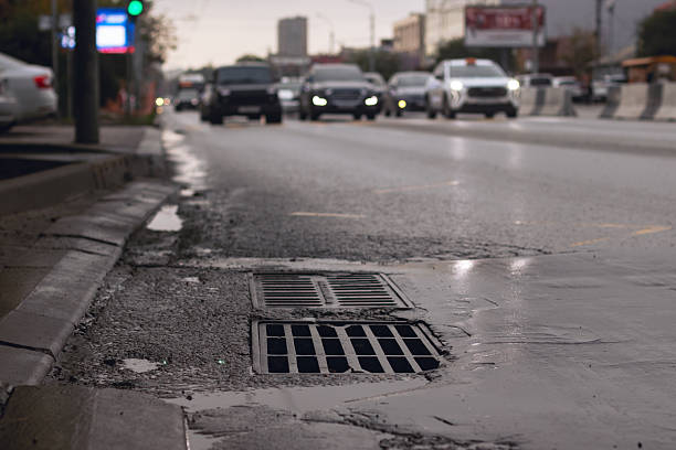 istock A city drain during rain with traffic in the background 2241658346