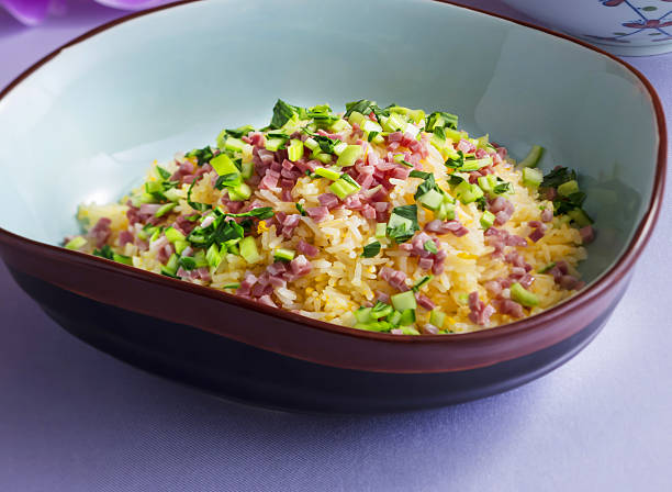 Fried Rice with ham, salted pork and fresh herbs in a stylish bowl, a delicious and colorful dish perfect for restaurant menus and food blogs