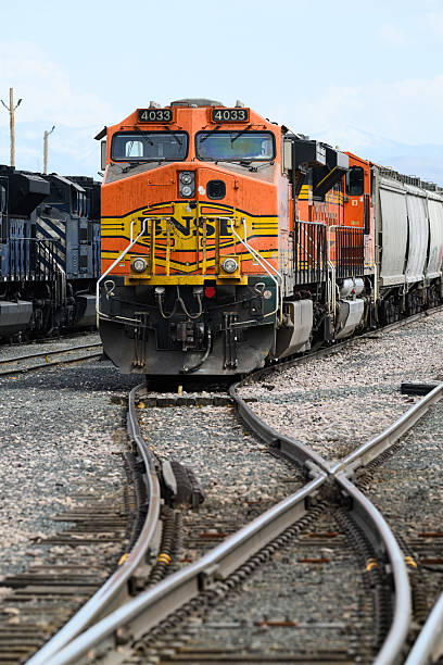 Helena, MT, USA - May 4, 2025; BNSF freight locomotive with cargo train at yard with track