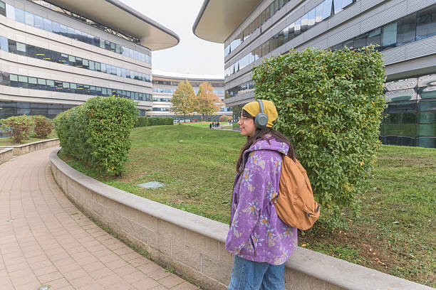 istock Student Walking on University Campus with Headphones and Backpack 2241661884