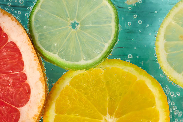Fresh citrus fruits in sparkling water create a refreshing summer drink experience with vibrant colors and textures
