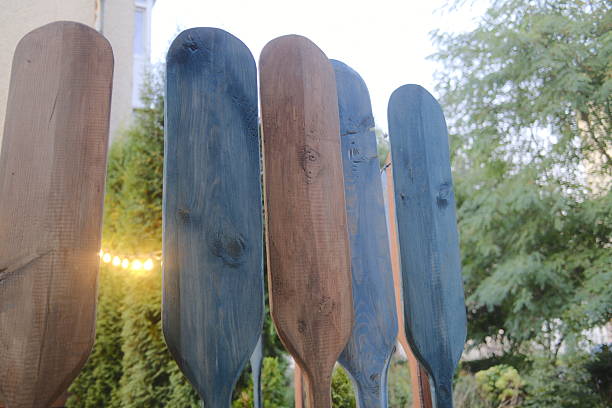 istock Decorative paddles, some blue and some brown, stand among green plants 2241663907