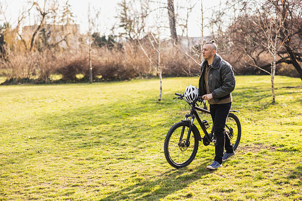 istock Man Walking With Bicycle In City Park 2241664083