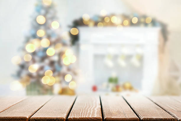 istock Warm Christmas bokeh background with wooden table and fireplace 2241666515