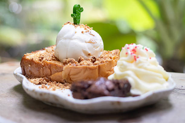Delicious dessert featuring toasted bread topped with creamy ice cream, whipped cream, and crunchy toppings, perfect for any sweet craving.