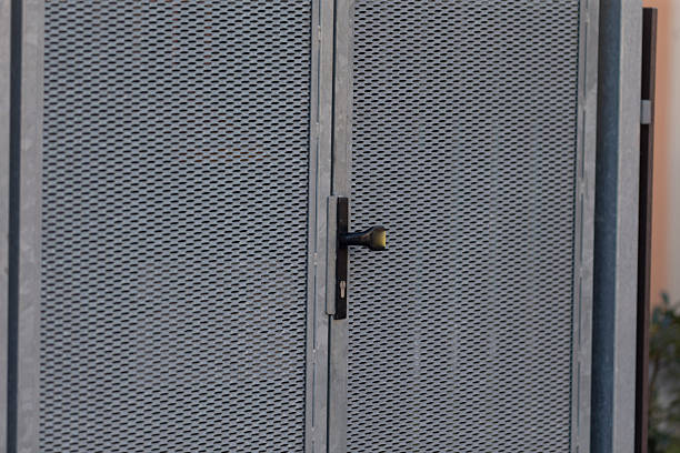 industrial perforated metal gate showcasing hinges and subtle lighting effects, design of textured perforated metal gate highlighting hinges and soft ambient lighting for industrial aesthetics
