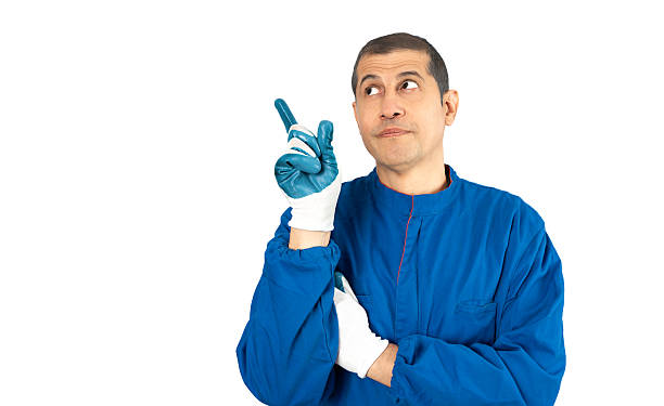 Portrait of a mechanic holding a wrench in front of his eye, smiling, in a car repair shop