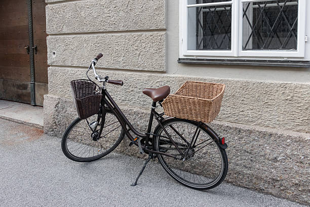 Cassic brown color bicycle with wicker baskets parked by Salzburg city street