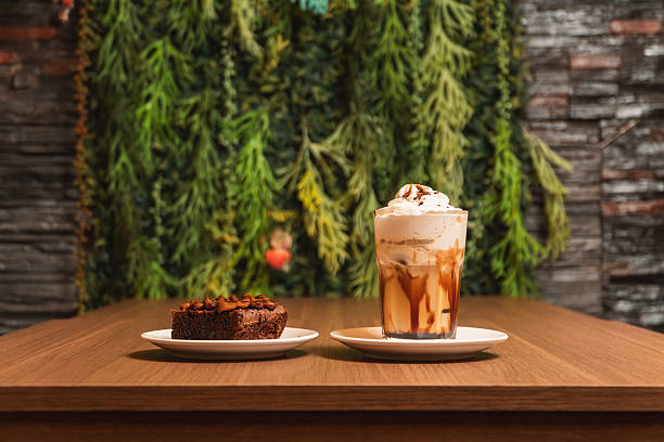 Coffee milkshake with a brownie served on different plates.