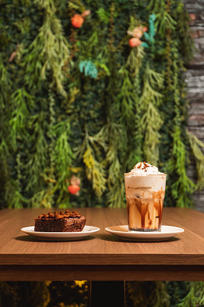 Coffee milkshake with a brownie served on different plates in a restaurant.