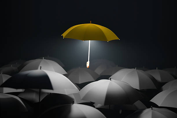 istock Creative yellow umbrella hovers and glows above black umbrellas, concept. Leader, creative idea. Think different. Concept for leadership with many blacks and yellow umbrella 2241677732