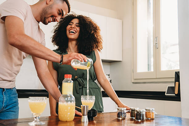 istock Happy couple enjoying making cocktails in kitchen 2241683809