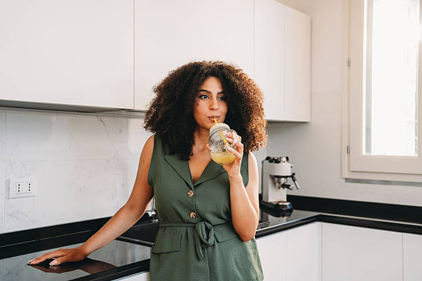 istock Woman drinking healthy juice in modern kitchen 2241683903