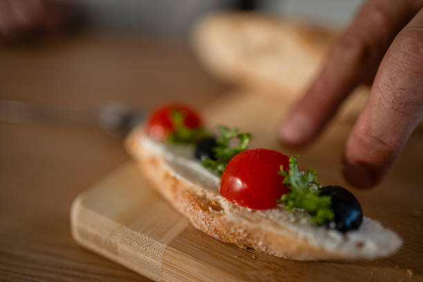 istock Hand preparing bruschetta appetizer with cherry tomatoes and olives 2241688867