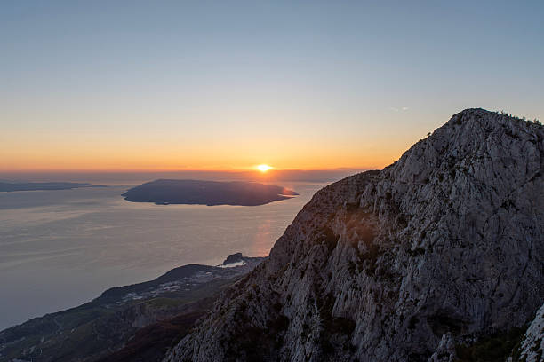 Sunset over sea and rocky mountain ridge