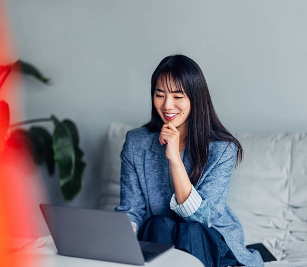 Young Professional Woman Using Laptop in Cozy Home Setting