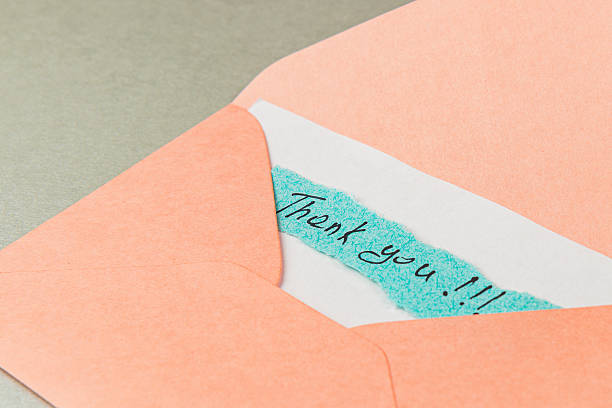 istock Thank you note in a pink envelope on a gray surface 2241694681