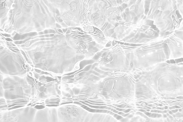 istock White water with ripples on the surface. Defocus blurred transparent white colored clear calm water surface texture with splashes and bubbles. Water waves with shining pattern texture background. 2241701767