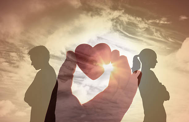 istock Two silhouetted people back to back with a double exposure of hands shaping a heart, symbolizing love, support, and connection under a radiant sunset sky. 2241704806