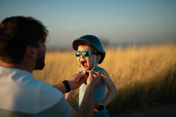 istock Father preparing his little boy for a bicycle ride at sunset. 2241708775