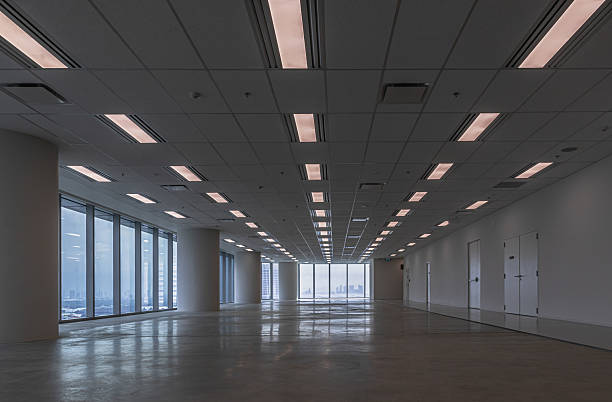 Bangkok, thailand - 11 Oct, 2025 - A large, empty room with a panoramic city skyline view through floor-to-ceiling windows. An empty office space with a polished, reflective floor and a grid of ceiling lights, use as Wallpaper, Poster and Space for text, Selective focus.