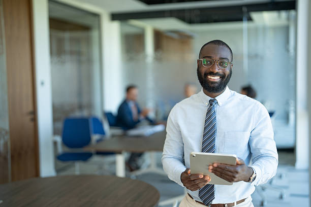 istock Smiling businessman holding digital tablet in modern office 2241709900