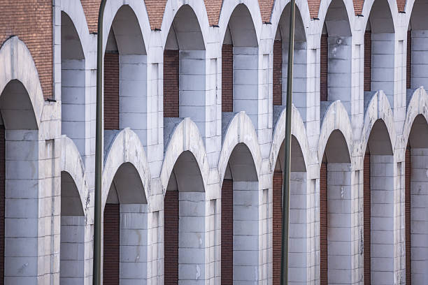 A brick wall with a multitude of white stone arches