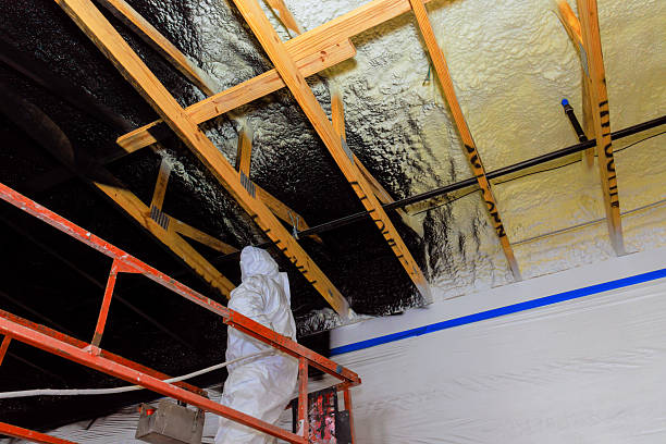 istock Worker sprays insulation on ceiling beams in construction site during renovation 2241719890