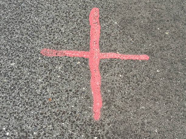 istock Red cross mark on asphalt surface indicating construction or survey marking 2241727246