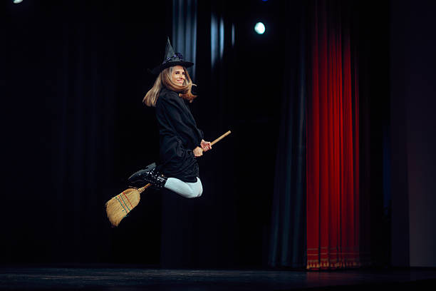 istock Funny Witch Flying on a Broom on a Theater Stage 2241729303
