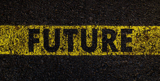 istock Yellow painted FUTURE text on black asphalt road surface, conceptual street art typography close-up 2241736951
