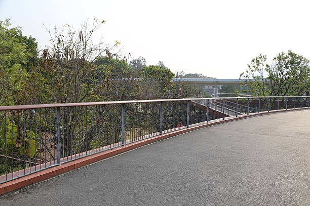 istock a wide sidewalk with a metal guardrail, overlooking the park below 2241737742