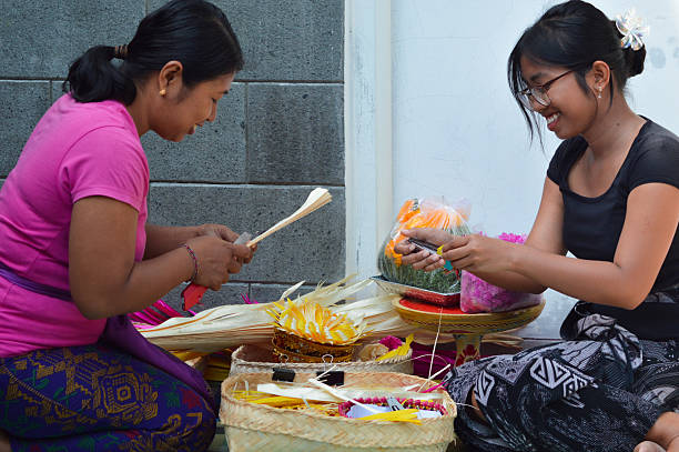 istock Balinese mother and daughter smiling while crafting leaf offerings 2241742576