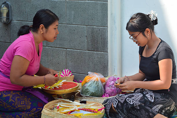 istock Balinese mother observes daughter practicing cultural leaf craft 2241742631