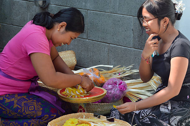istock Balinese mother crafting floral patterned leaf weaving with child 2241742667