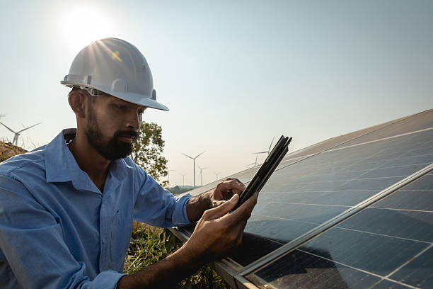istock Young Asian engineer with beard inspects solar panels with tablet, renewable energy for the future concept 2241743188