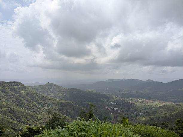 istock Expansive green valley and cliffs beneath cloudy sky during monsoon 2241749595
