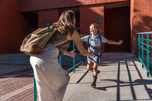 istock Happy mother and daughter reuniting at school after classes 2241751035
