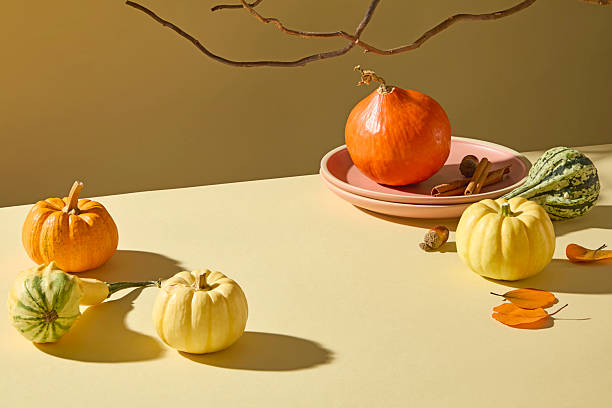 istock Pumpkin and tableware arranged neatly on light beige table. Warm autumn aesthetic ideal for food photography, Thanksgiving, and harvest visuals. 2241751084