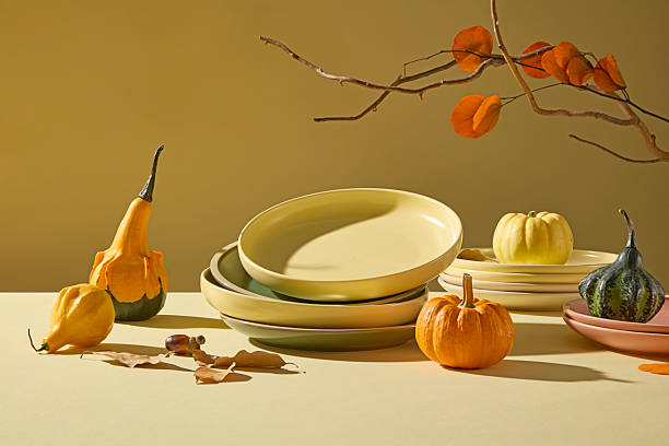 istock Stacked tableware and pumpkins on warm background. Soft beige tones create a cozy fall aesthetic perfect for Thanksgiving campaigns or food design. 2241751145