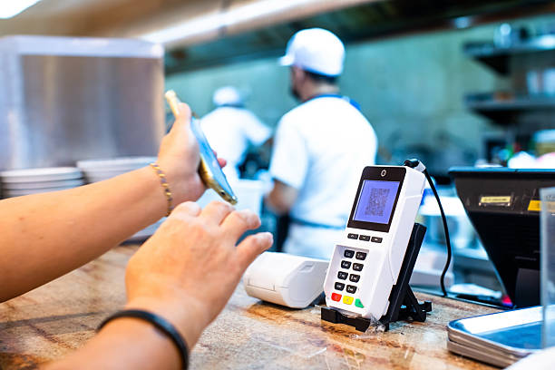 istock Selective focus to POS smart device with blurry custom hand holding smartphone to scan QR code on it with chef in backgroung in restaurant for accepted generate digital payment. 2241752345