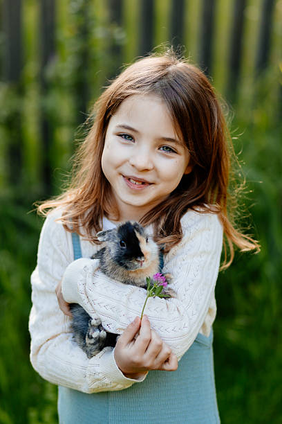 istock Young girl gently cuddles a fluffy bunny in her arms. 2241752632