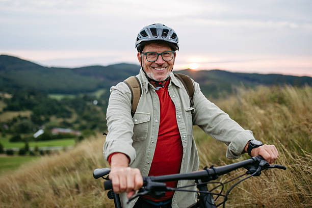 istock Smiling senior man cycling in nature at sunset. 2241754869