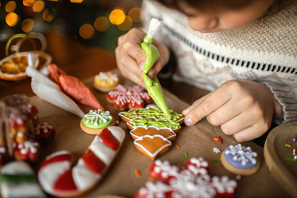 istock Boy decorating Christmas gingerbread cookies 2241757455