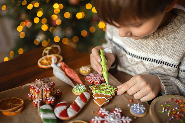 Boy decorating Christmas gingerbread cookies