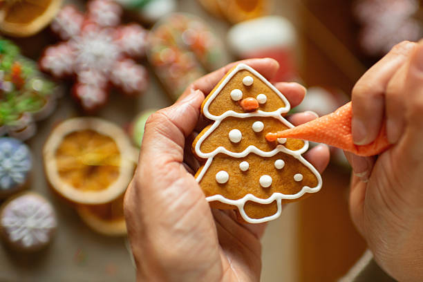 istock Woman decorating Christmas gingerbread cookies 2241757528