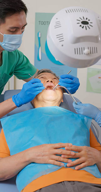 istock asian male dentist examine elderly patient teeth 2241763677